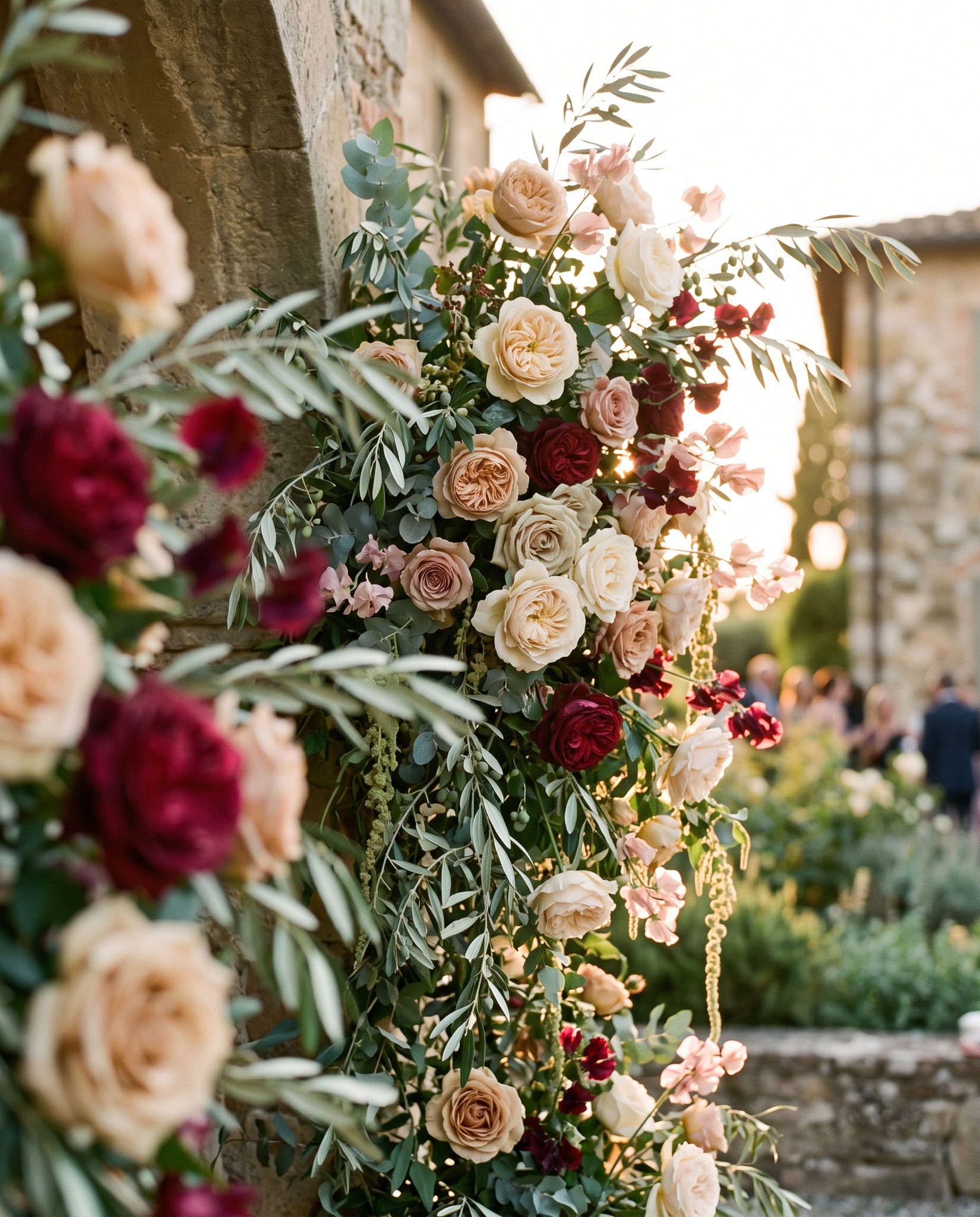 Backlit floral installation of garden roses, sweet peas and olive branches