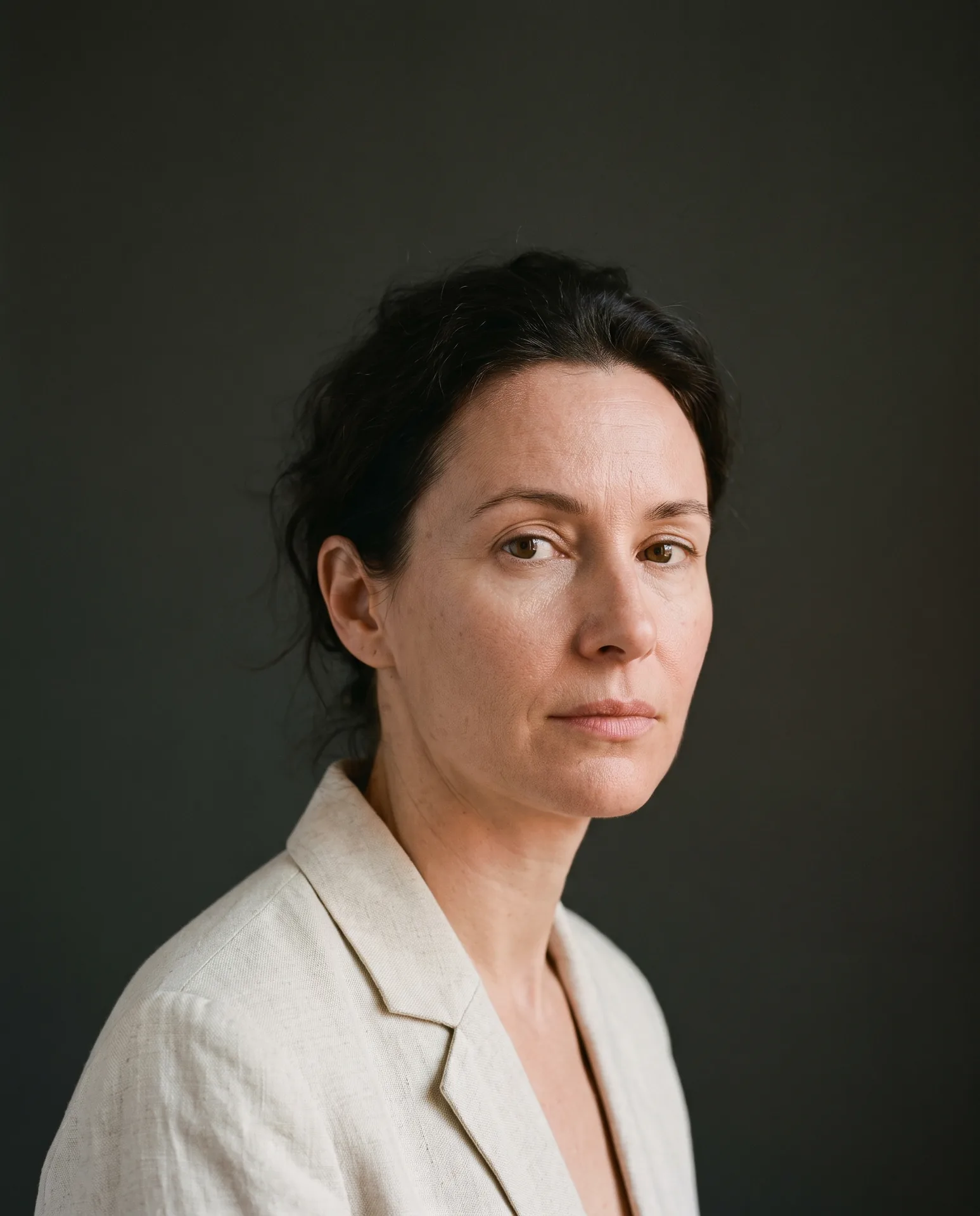 Elena Orlova — editorial portrait against a warm graphite backdrop